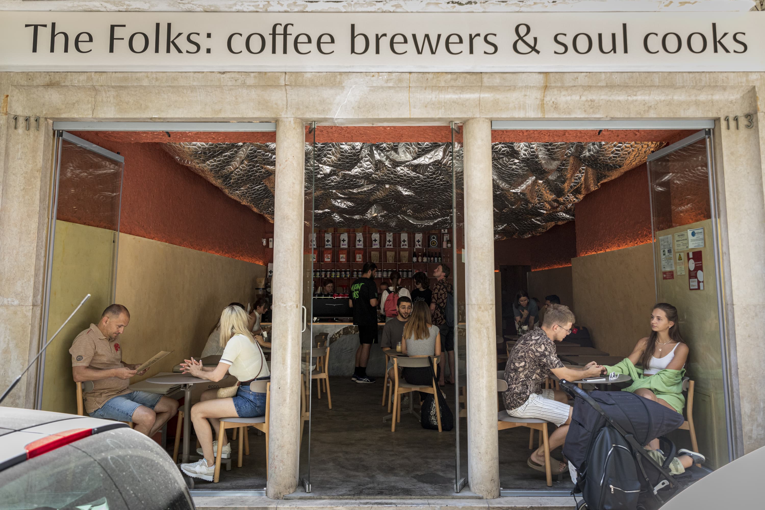 The Folks Chiado interior with white padded ceiling and espresso bar