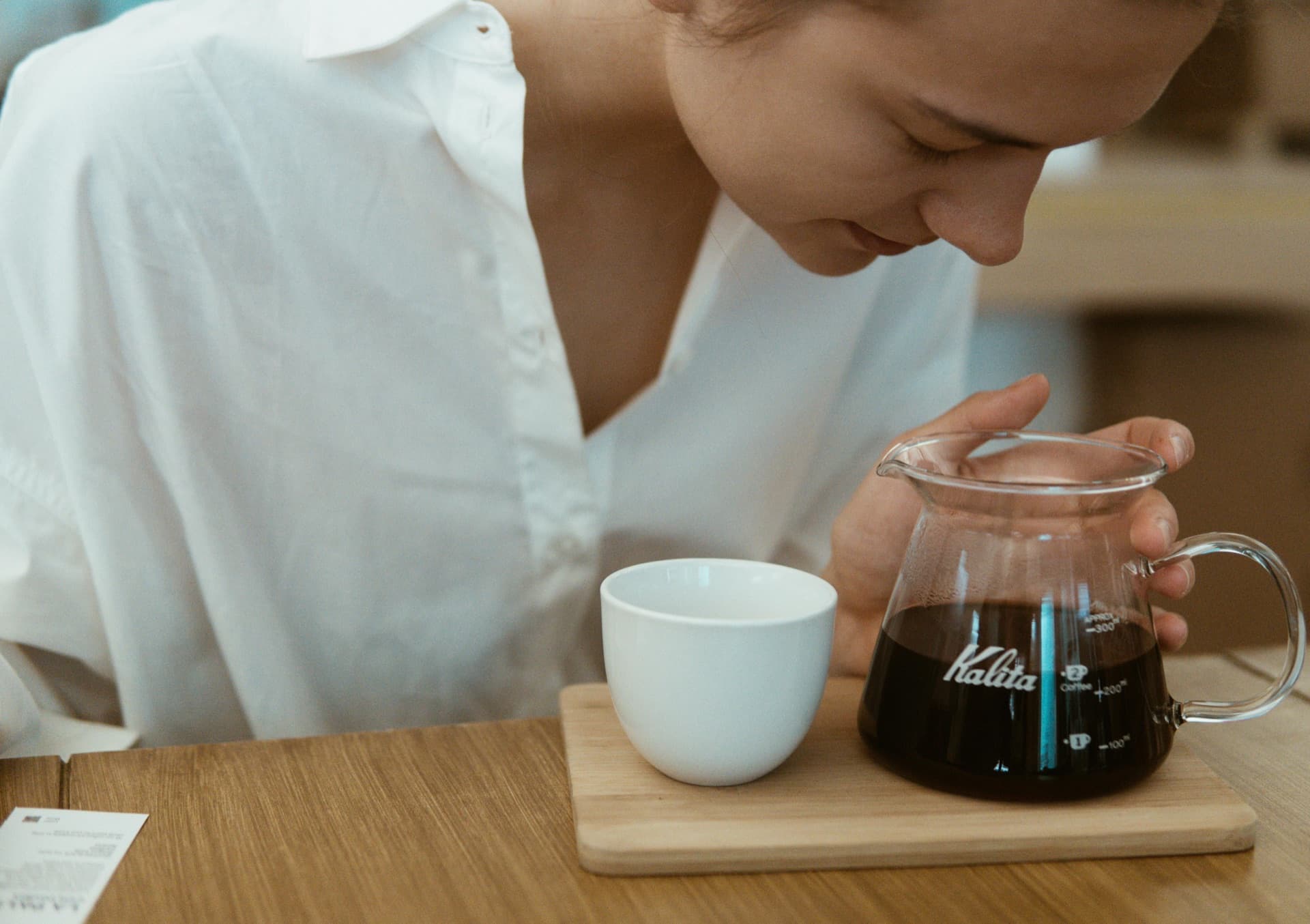 Brewer leaning in to smell fresh-brewed coffee