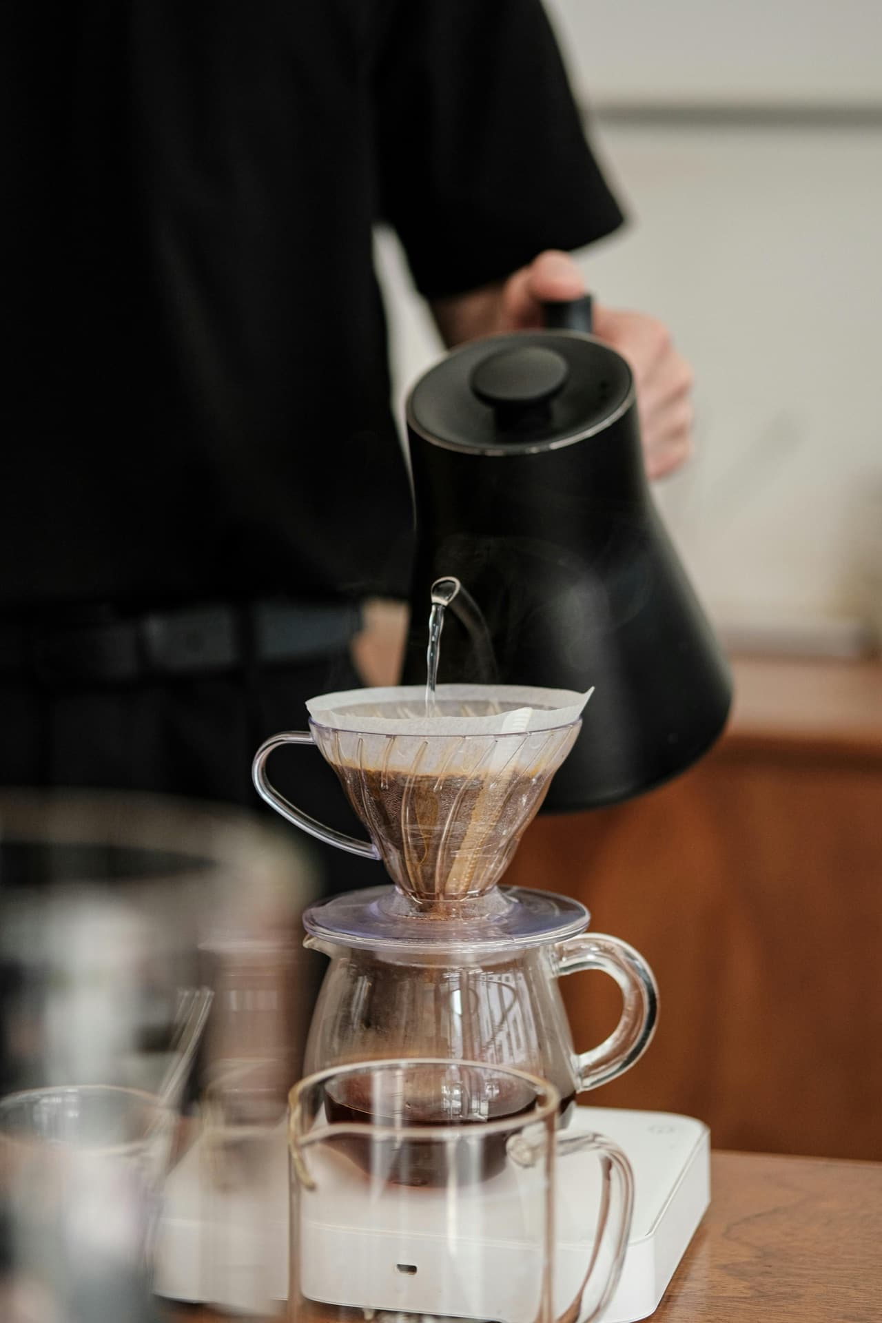 Brewer pouring water through a V60 dripper